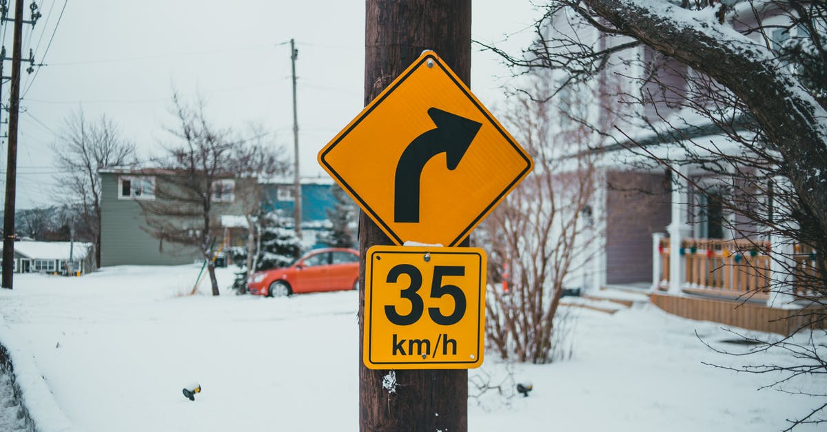 The limit number of batteries I can take within a flight? - Control road signs with arrow showing turn under speed limit on post against buildings with snow in wintertime The limit number of batteries I can take within a flight? - Control road signs with arrow showing turn under speed limit on post against buildings with snow in wintertime