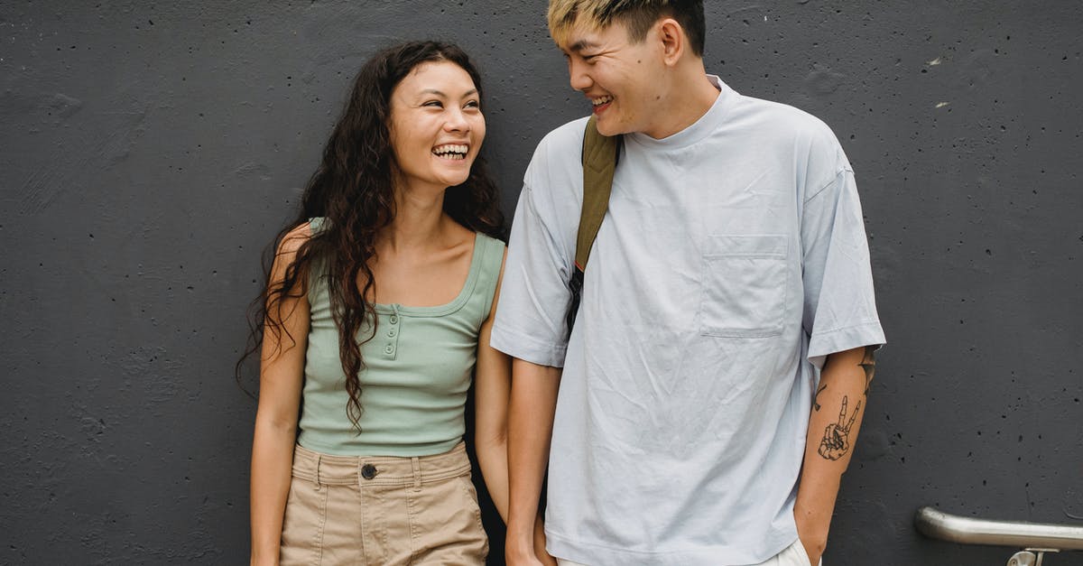 The most pleasant cities to stay in Ireland, other than Dublin? [closed] - Delighted diverse couple standing together and looking at each other against gray stone wall in daytime