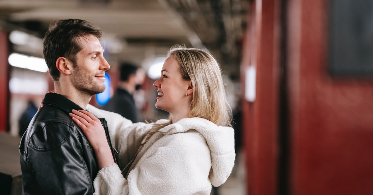 The most pleasant cities to stay in Ireland, other than Dublin? [closed] - Side view of cheerful couple in trendy clothes embracing in underground corridor and looking at each other