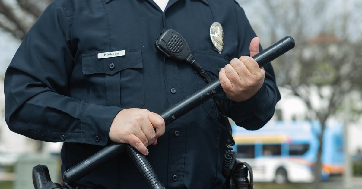 The officer wrote a "code" in my passport - Man in Black Police Uniform Holding Black Metal Rod The officer wrote a "code" in my passport - Man in Black Police Uniform Holding Black Metal Rod