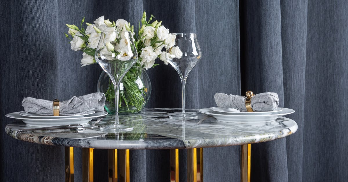 The purpose of glass goblets with coins in Italian cafes - Glasses and plates arranged with bunch of flowers in vase on marble table The purpose of glass goblets with coins in Italian cafes - Glasses and plates arranged with bunch of flowers in vase on marble table
