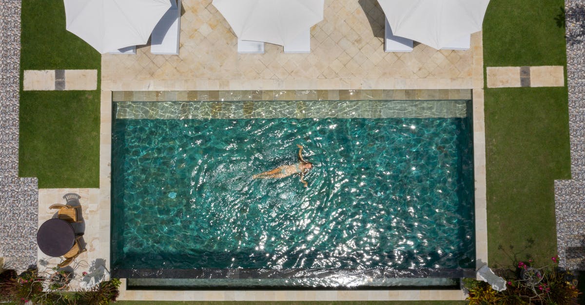 The Schengen zone and how to count the 90 days as a tourist after a long term visa [duplicate] - Drone view of anonymous female tourist relaxing in pool water near terrace with white parasols among green lawns in comfortable hotel zone during vacation