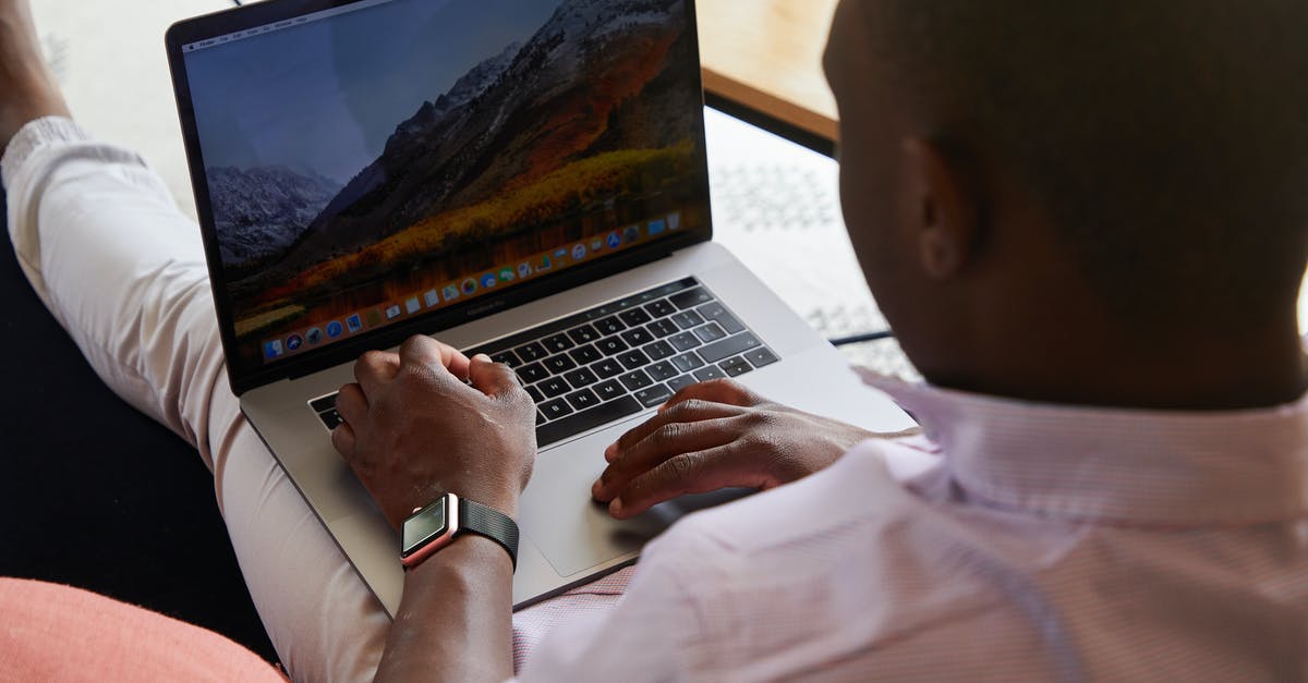 Time taken for customs check in Brisbane Australia - Black man with smart watch using touchpad of laptop Time taken for customs check in Brisbane Australia - Black man with smart watch using touchpad of laptop