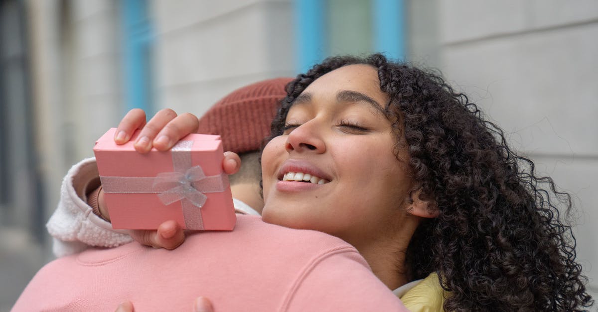Time taken to receive ESTA approval - Content Hispanic girlfriend with gift box in hand embracing anonymous boyfriend while standing on street on blurred background during romantic date Time taken to receive ESTA approval - Content Hispanic girlfriend with gift box in hand embracing anonymous boyfriend while standing on street on blurred background during romantic date