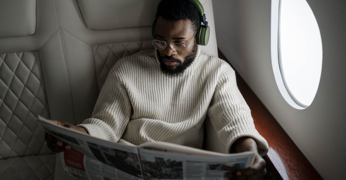 Tips and tricks surviving a long-haul flight departing at midnight - Man Reading a Newspaper Tips and tricks surviving a long-haul flight departing at midnight - Man Reading a Newspaper
