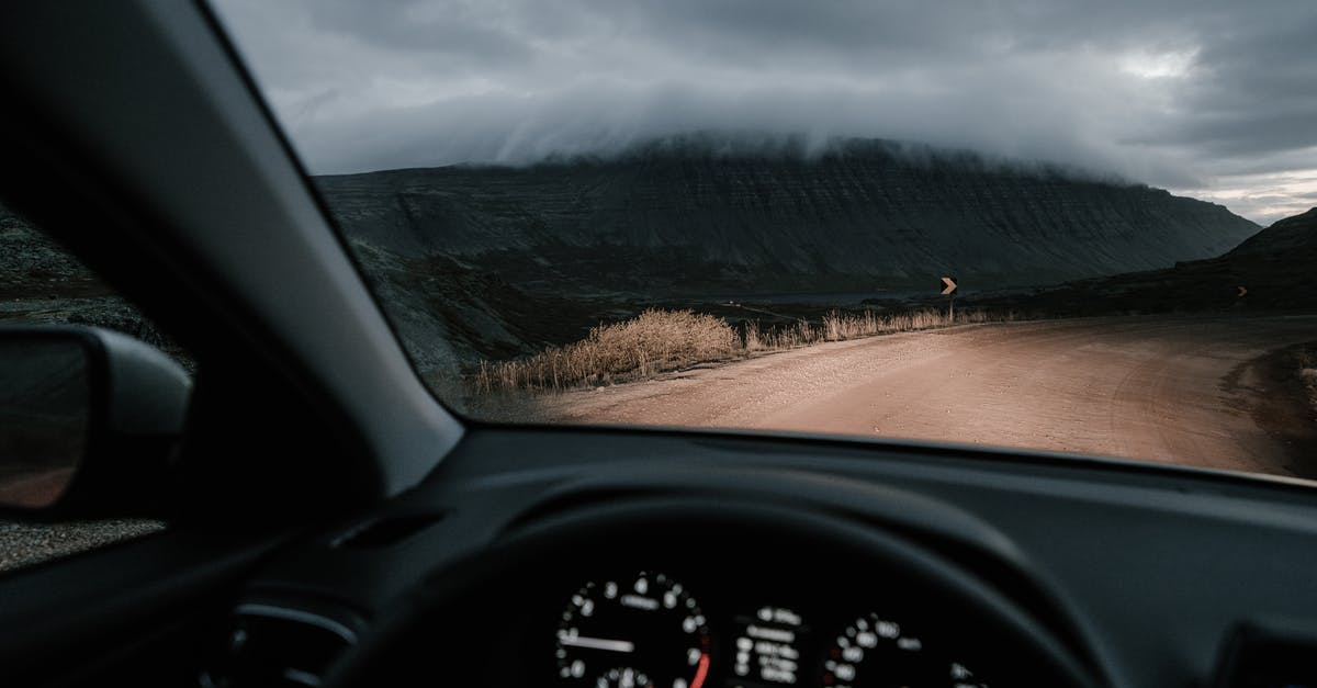 Tips for driving on a different side of the road? [duplicate] - View from inside car on road in countryside near mounts and faded grass in mist under cloudy sky