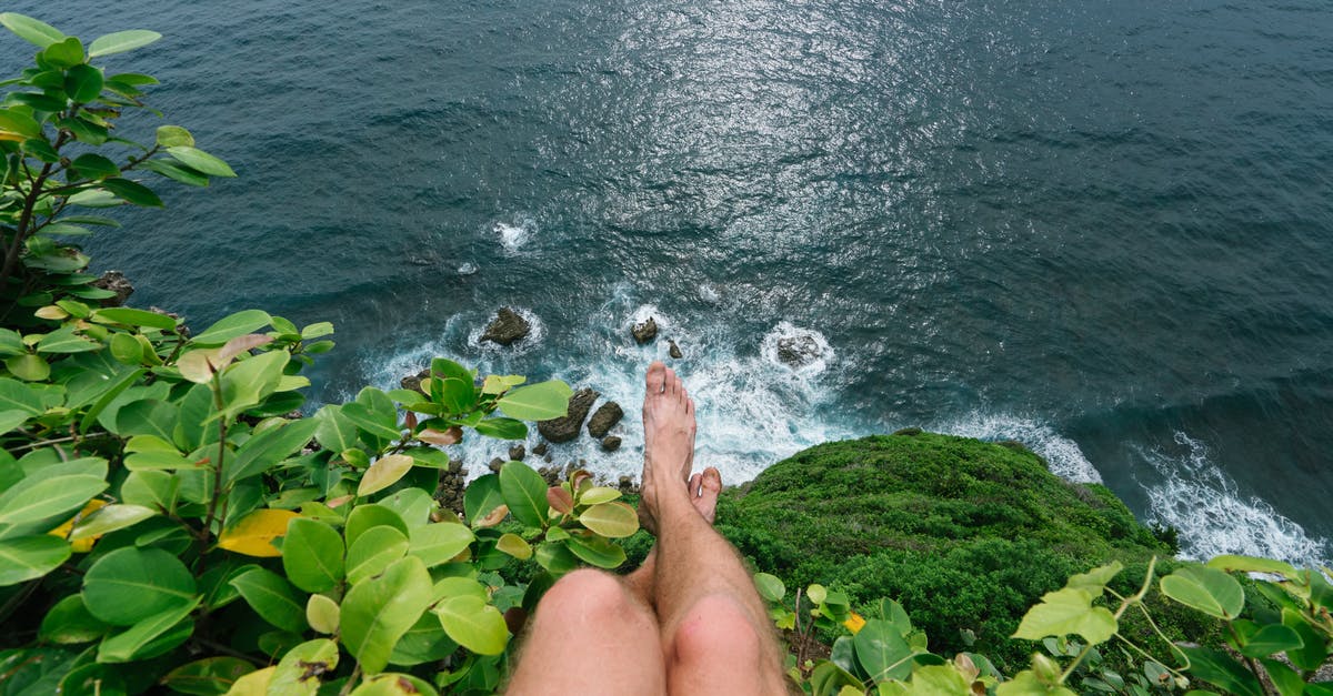 toll cost for my trip [duplicate] - Faceless barefoot man sitting on high cliff
