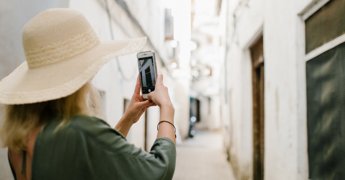 Tourist cell phone use in Myanmar - Woman taking photo of building in alley Tourist cell phone use in Myanmar - Woman taking photo of building in alley