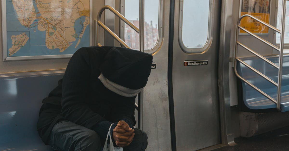 Train from Vancouver to Seattle Airport - Person in Black Hoodie Sitting on Train Bench Train from Vancouver to Seattle Airport - Person in Black Hoodie Sitting on Train Bench