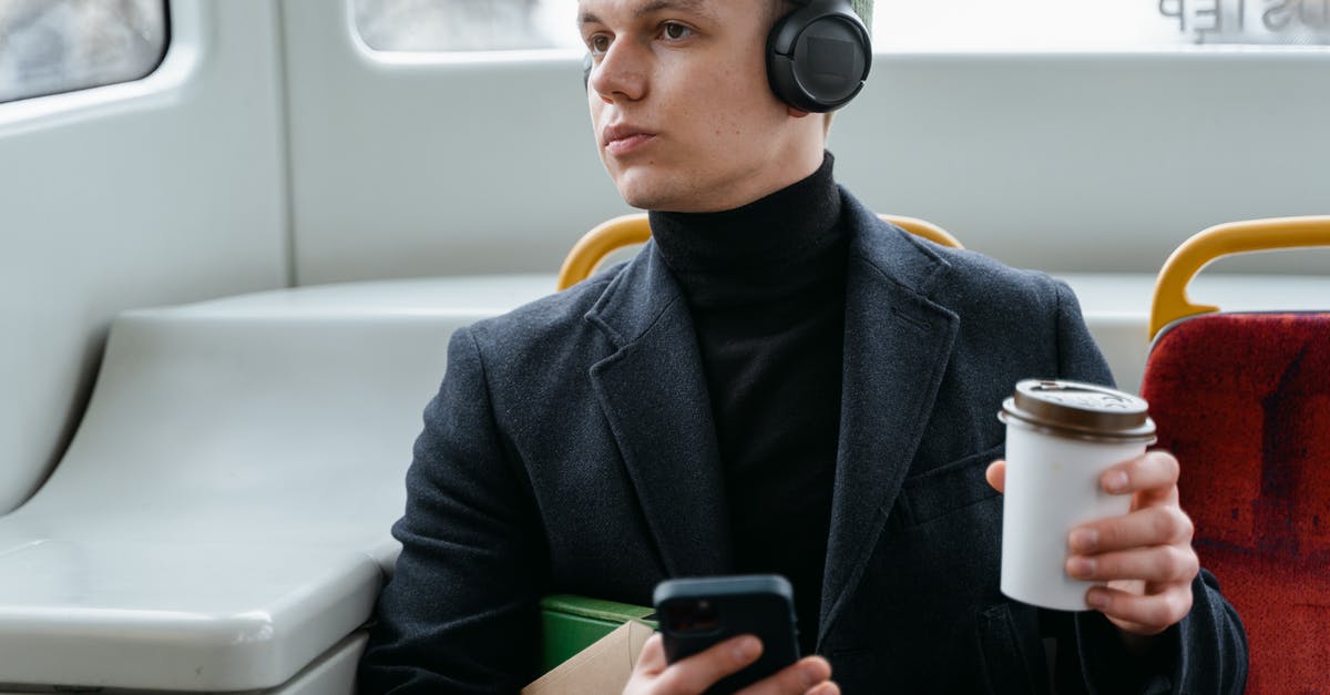 Train travel in Russia between host cities during Football World Cup 2018 - Man Listening to Music and Holding a Cup of Coffee Train travel in Russia between host cities during Football World Cup 2018 - Man Listening to Music and Holding a Cup of Coffee