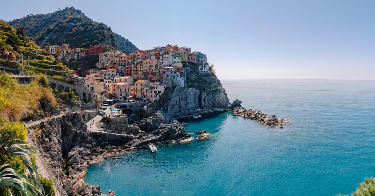 Trains in the Cinque Terre - Breathtaking scenery of historic colorful buildings of famous coastal Manarola town located on stony hill in front of turquoise sea on sunny day Trains in the Cinque Terre - Breathtaking scenery of historic colorful buildings of famous coastal Manarola town located on stony hill in front of turquoise sea on sunny day