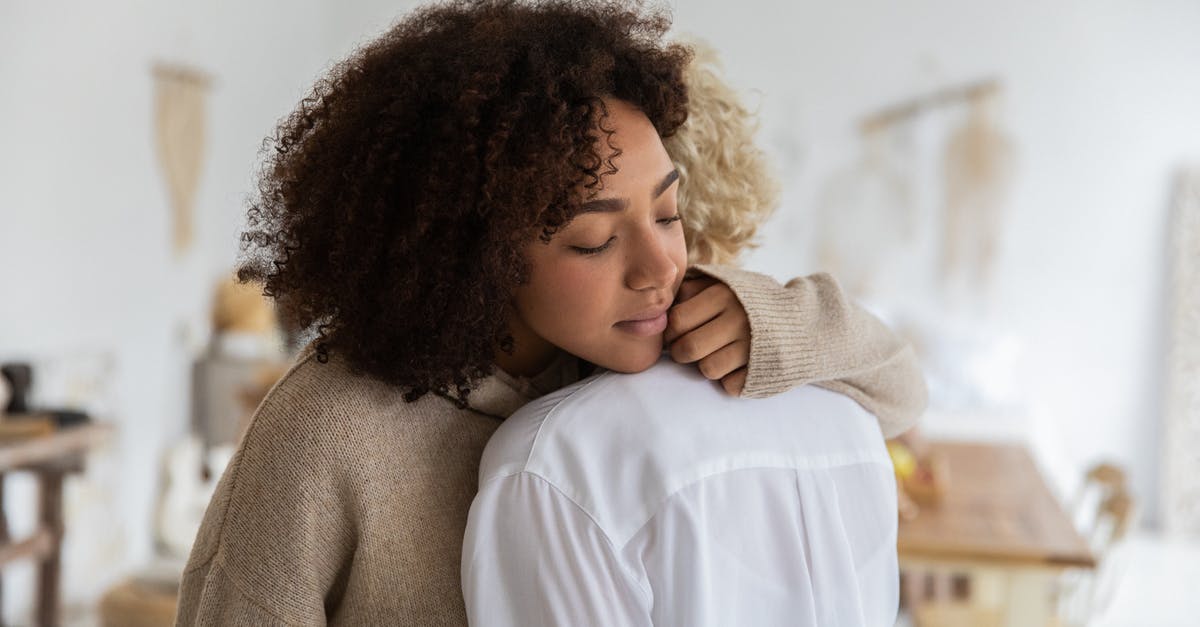 Transfer time at Newark domestic to domestic different carriers - African American woman embracing female anonymous friend while standing in cozy light room with wooden table and decorations on wall with blurred background Transfer time at Newark domestic to domestic different carriers - African American woman embracing female anonymous friend while standing in cozy light room with wooden table and decorations on wall with blurred background