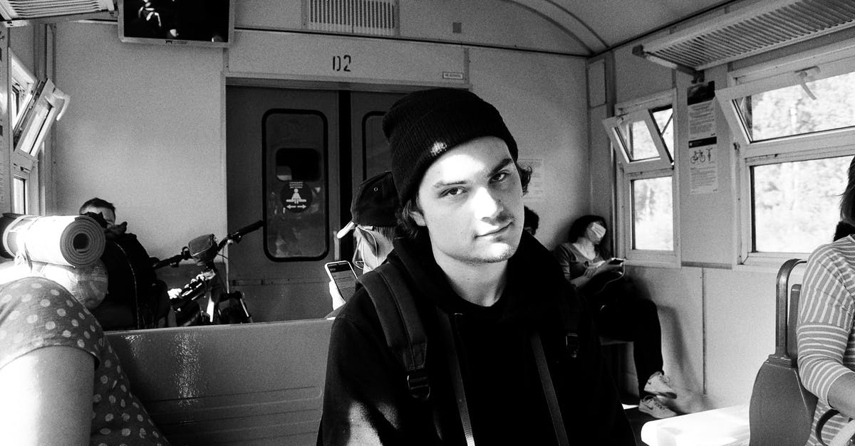 Transit counted as Schengen days? - Black and white of young man in black clothes siting on seat in train in sunny day Transit counted as Schengen days? - Black and white of young man in black clothes siting on seat in train in sunny day
