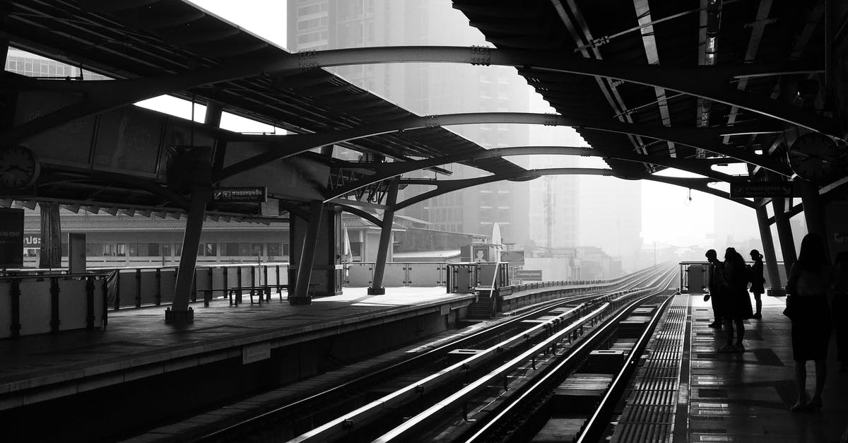 Transit in DXB between terminal 2 to 1 - Silhouettes of anonymous people standing on railway platform Transit in DXB between terminal 2 to 1 - Silhouettes of anonymous people standing on railway platform