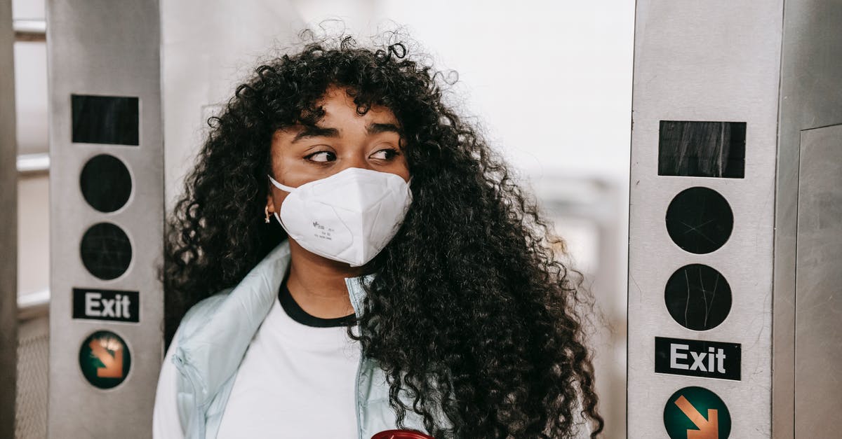 Transit in DXB between terminal 2 to 1 - Black woman in mask passing through underground turnstile Transit in DXB between terminal 2 to 1 - Black woman in mask passing through underground turnstile
