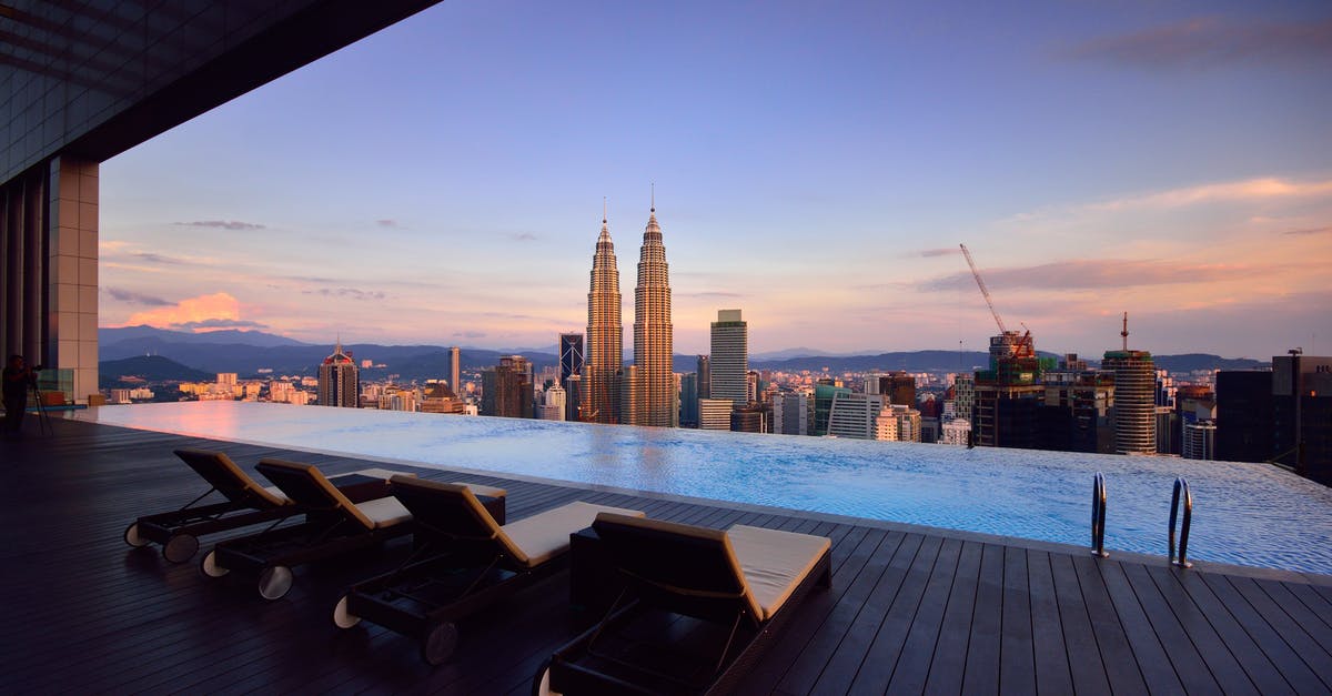 Transiting at Kuala Lumpur - Brown Lounge Chair on Side of Swimming Pool Transiting at Kuala Lumpur - Brown Lounge Chair on Side of Swimming Pool
