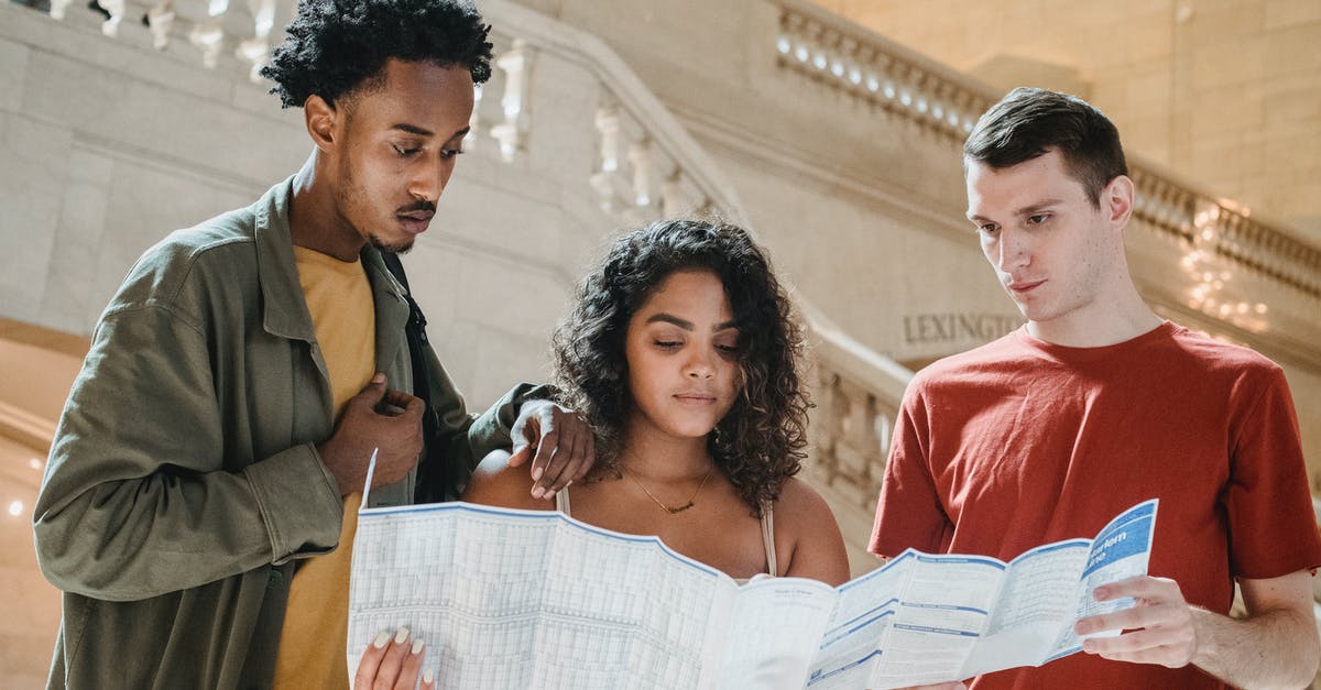 Transiting Brussels, after having lost your passport in the USA - Serious young diverse millennials reading map in railway station terminal Transiting Brussels, after having lost your passport in the USA - Serious young diverse millennials reading map in railway station terminal