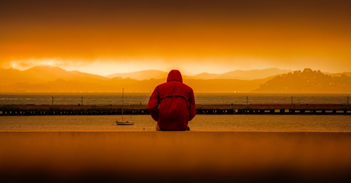 Transiting through America then returning by boat [closed] - Person Wearing Red Hoodie Sitting In Front of Body of Water
