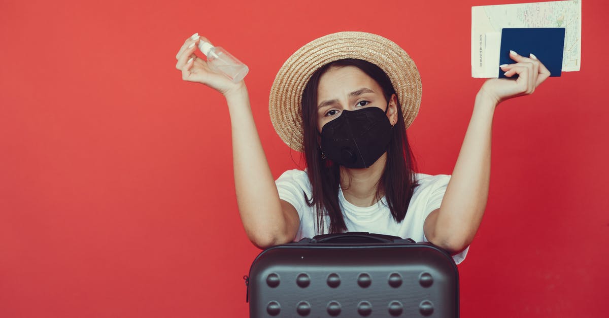 Travel agent booked ticket when passport has less than 3 months left - Young woman in medical mask and wicker hat holding passport and sanitizing spray while sitting behind suitcase and shrugging hand on red background Travel agent booked ticket when passport has less than 3 months left - Young woman in medical mask and wicker hat holding passport and sanitizing spray while sitting behind suitcase and shrugging hand on red background