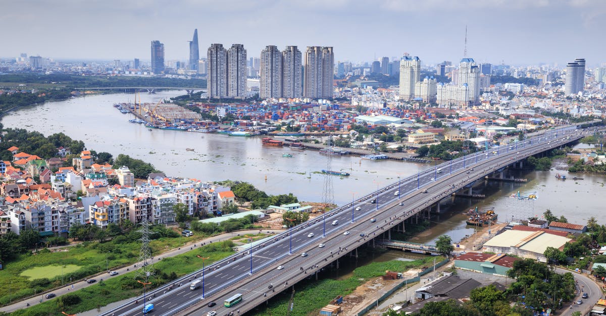 Travel between Ho Chi Minh City and Kampot - Different Vehicles on Road Near High-rise Buildings Showing Bridge and Sea Travel between Ho Chi Minh City and Kampot - Different Vehicles on Road Near High-rise Buildings Showing Bridge and Sea
