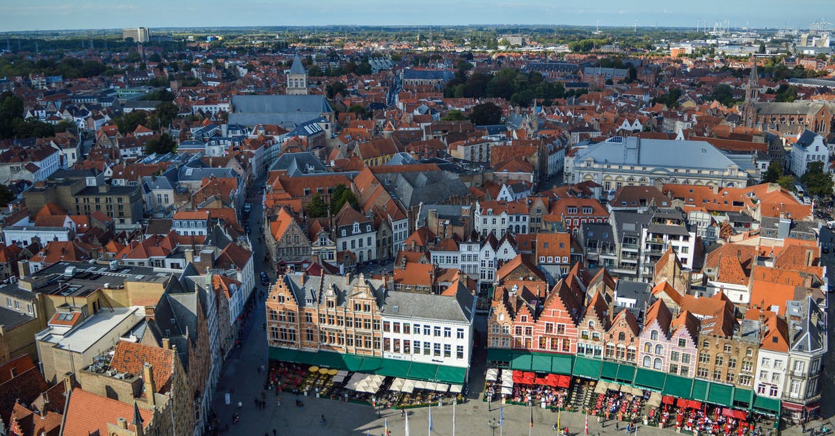 Travel from Belgium to Romania with French "Récépissé de renouvellement de Titre de Séjour" - Amazing aerial view of Markt square and aged typical buildings in historical center of Bruges on sunny day Travel from Belgium to Romania with French "Récépissé de renouvellement de Titre de Séjour" - Amazing aerial view of Markt square and aged typical buildings in historical center of Bruges on sunny day
