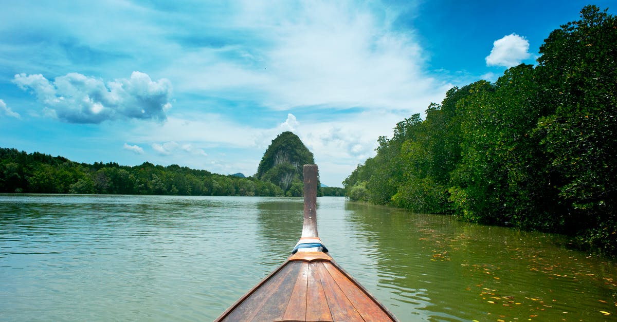 Travel from Krabi to Koh Yao Yai - Brown Wooden canoe near trees Travel from Krabi to Koh Yao Yai - Brown Wooden canoe near trees