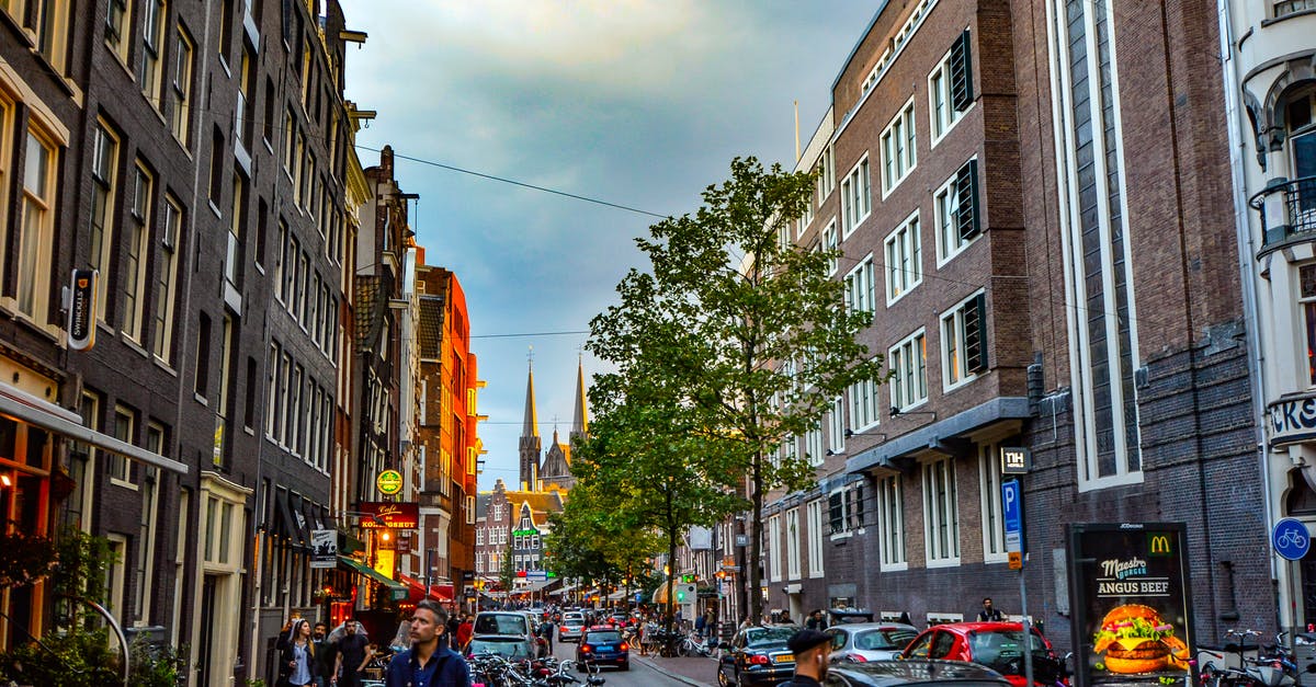 Travel to Amsterdam on Schengen business visa for tourist purpose - Man Standing in Front of Brown Concrete Building Travel to Amsterdam on Schengen business visa for tourist purpose - Man Standing in Front of Brown Concrete Building