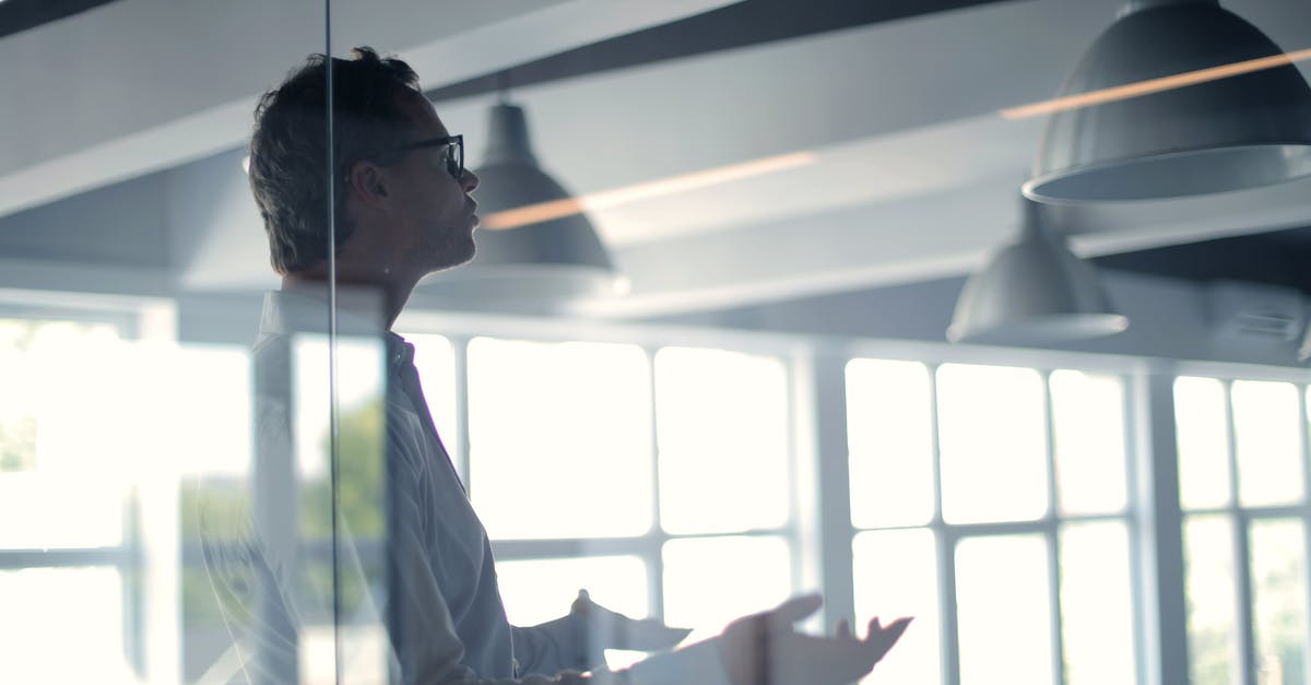 Travel to UK on a business visa from old company - Male employer gesticulating and explaining idea in light office Travel to UK on a business visa from old company - Male employer gesticulating and explaining idea in light office