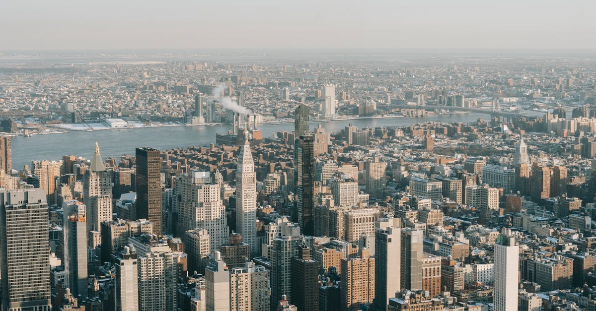 Travel to USA while working remotely for US company - Spectacular drone view of New York City skyline with modern skyscrapers and towers near Hudson River on sunny day Travel to USA while working remotely for US company - Spectacular drone view of New York City skyline with modern skyscrapers and towers near Hudson River on sunny day