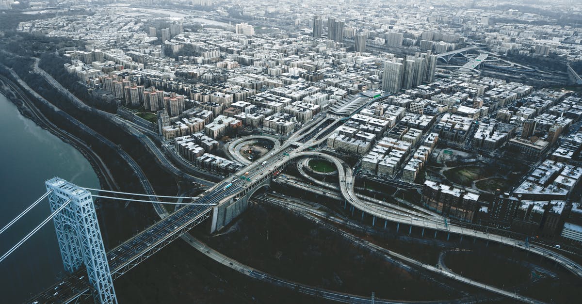 Travel to USA while working remotely for US company - Drone view of George Washington Bridge crossing river and connecting districts of New York City against cloudy sky Travel to USA while working remotely for US company - Drone view of George Washington Bridge crossing river and connecting districts of New York City against cloudy sky