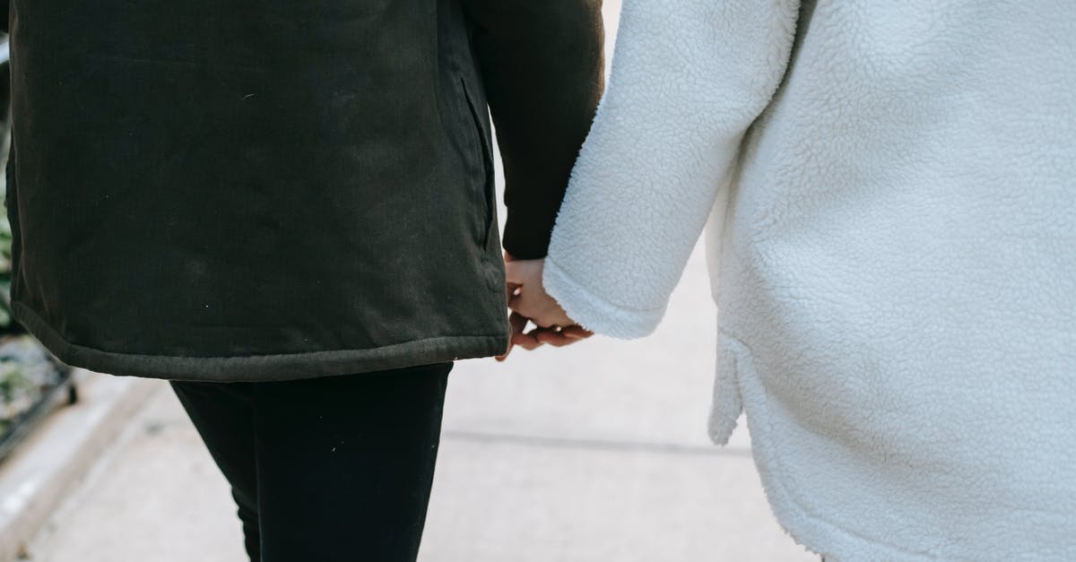 Traveling back from Bangladesh [closed] - Faceless trendy couple holding hands and walking on street