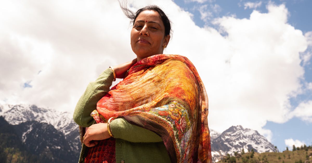 Traveling from cold region to warm region; tips regarding clothing? - Positive ethnic female resting in village near mountains Traveling from cold region to warm region; tips regarding clothing? - Positive ethnic female resting in village near mountains