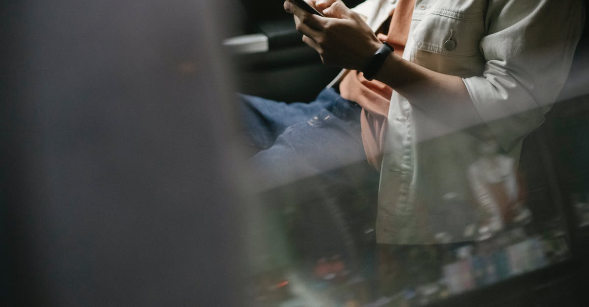 Traveling from JNB to DUB through IST - Crop man messaging on smartphone while sitting in car Traveling from JNB to DUB through IST - Crop man messaging on smartphone while sitting in car