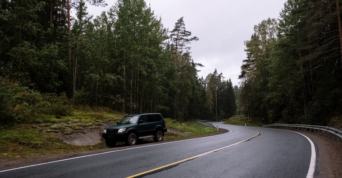 Traveling the Camino Trail during Covid - Black Suv on Roadside Between Green Trees Traveling the Camino Trail during Covid - Black Suv on Roadside Between Green Trees