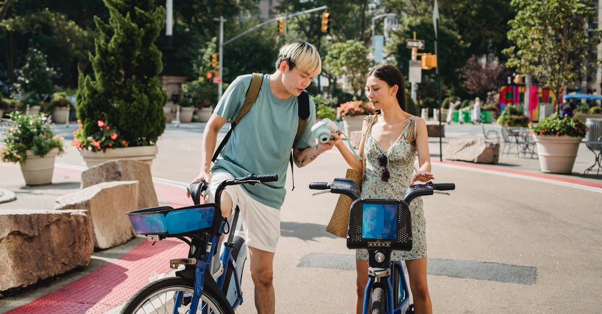 Traveling to Thailand, immigration and customs check 3 times? - Multiracial friends riding on bicycles with camera in park with green plants in sunny weather in summer Traveling to Thailand, immigration and customs check 3 times? - Multiracial friends riding on bicycles with camera in park with green plants in sunny weather in summer
