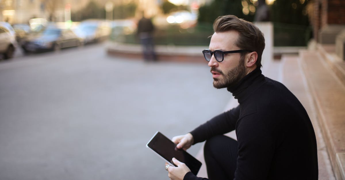 Traveling to the Bahamas now worried about robbery sexual assault - Side view of trendy serious bearded male in glasses and black casual clothes with notebook looking away and thinking while sitting on exterior stairs at entrance of modern building in downtown Traveling to the Bahamas now worried about robbery sexual assault - Side view of trendy serious bearded male in glasses and black casual clothes with notebook looking away and thinking while sitting on exterior stairs at entrance of modern building in downtown