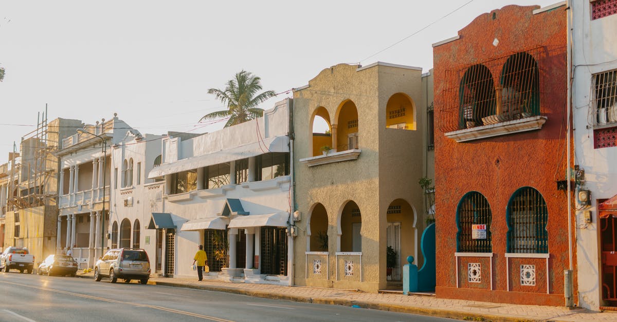 Traveling with a 9-year old in the Red Sea Riviera, Hurghada, East Egypt area? [closed] - Aged masonry building exteriors with arches near asphalt roadway with automobiles in Egypt in sunlight