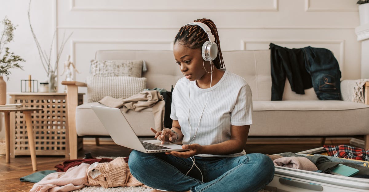Traveling with a lot of luggage at Heathrow - getting help? - A Woman Using Her Laptop with Headphones On Traveling with a lot of luggage at Heathrow - getting help? - A Woman Using Her Laptop with Headphones On