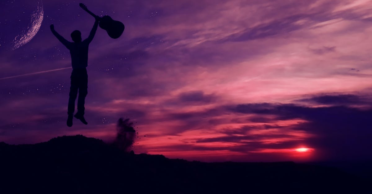 Traveling with guitar on AirEuropa - Silhouette of Man Holding a Guitar