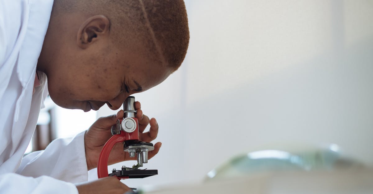 Traveling with medical equipment in checked baggage - Focused biologist studying plant leaf with microscope Traveling with medical equipment in checked baggage - Focused biologist studying plant leaf with microscope