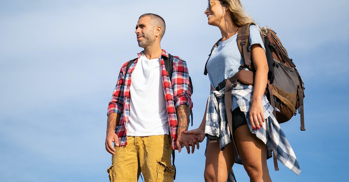 Traveling within the EU as a minor - Happy Couple with Backpacks against Blue Sky Traveling within the EU as a minor - Happy Couple with Backpacks against Blue Sky