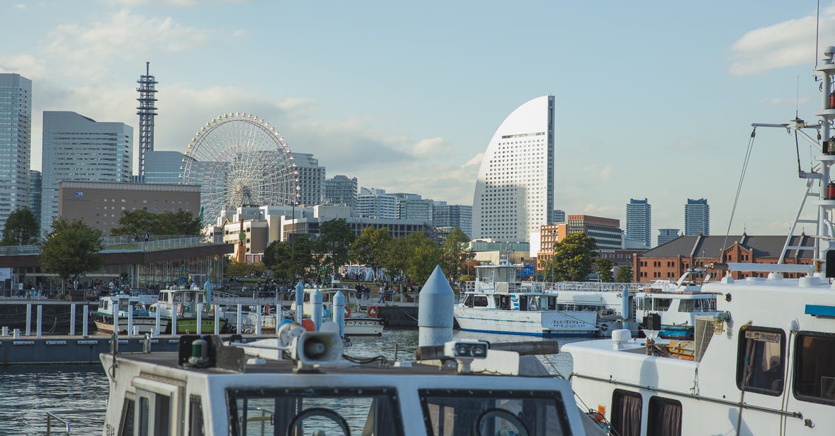Travelling around Japan on a cruise ship - Vessels moored in harbor of modern urban city Travelling around Japan on a cruise ship - Vessels moored in harbor of modern urban city