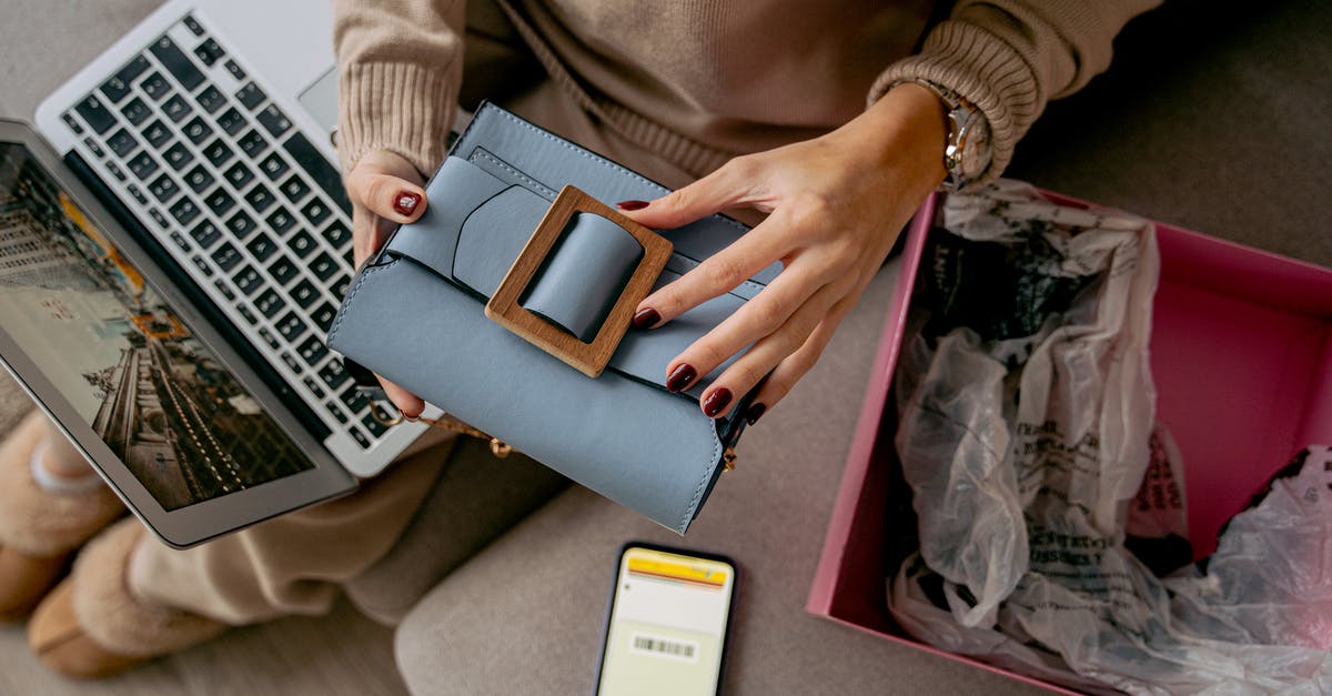 Travelling back to India with a phone purchased (and unboxed) in Netherlands [duplicate] - Woman Sitting on a Couch with a Laptop on Her Lap and Holding a New Purchase