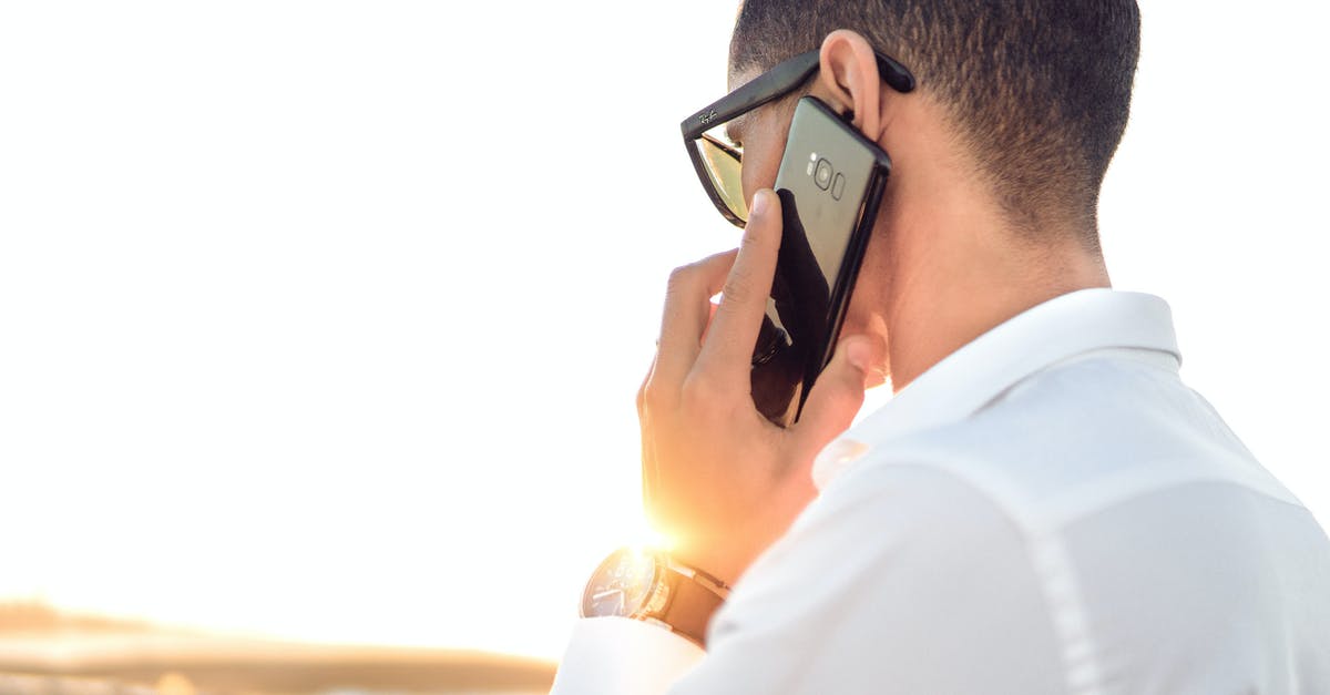 Travelling back to India with a phone purchased (and unboxed) in Netherlands [duplicate] - Shallow Focus Photography of a Man in White Collared Dress Shirt Talking to the Phone Using Black Android Smartphone