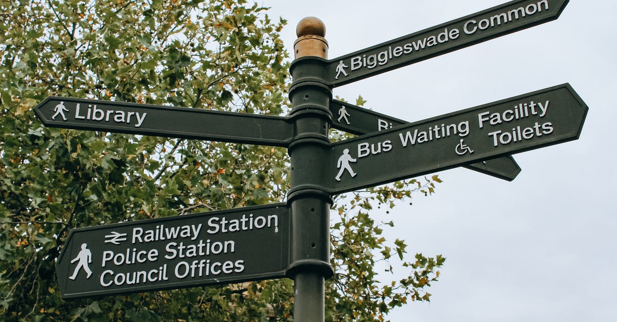 Travelling from the UK to Spain, have lost passport, any ideas? - From below poled signpost placed near lush green tree and showing direction to city facilities in daylight Travelling from the UK to Spain, have lost passport, any ideas? - From below poled signpost placed near lush green tree and showing direction to city facilities in daylight