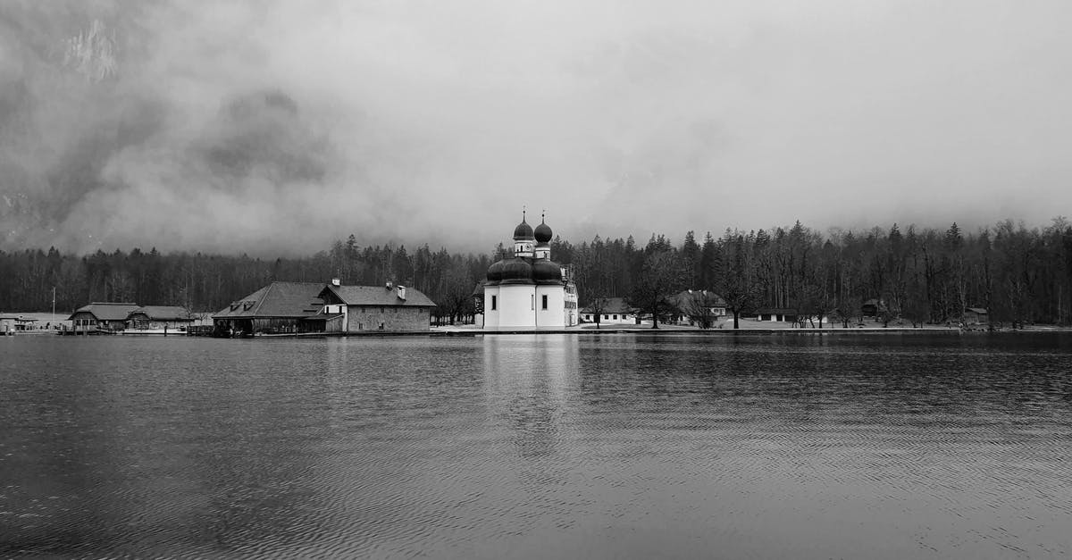 Travelling in Germany as a 17 year old. What do I need? - Black and white scenery of old St Bartholomew Church built on pond coast in peaceful countryside area Travelling in Germany as a 17 year old. What do I need? - Black and white scenery of old St Bartholomew Church built on pond coast in peaceful countryside area