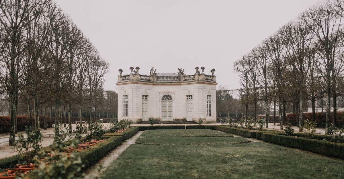 Travelling out of France with a receipt for first residence permit - Exterior of ornamental modern palace with white walls and big cozy windows decorated with statues on roof located in beautiful park on autumn overcast day Travelling out of France with a receipt for first residence permit - Exterior of ornamental modern palace with white walls and big cozy windows decorated with statues on roof located in beautiful park on autumn overcast day
