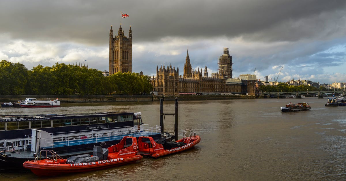 Travelling outside the UK without a passport - Boats floating on river against Palace of Westminster Travelling outside the UK without a passport - Boats floating on river against Palace of Westminster