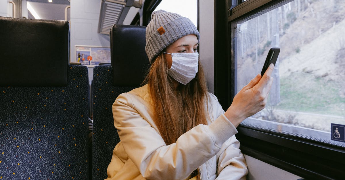 Travelling Requirements to Schengen Countries using Romanian Visa for Non-European Citizen [closed] - Woman in Beige Jacket and Gray Knit Cap Holding Smartphone