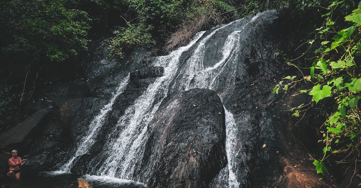 Travelling through UK, what is considered a "common format residence permit"? - Unrecognizable travelers chilling in warm pond formed by waterfall flowing through rough stony cliff in lush forest Travelling through UK, what is considered a "common format residence permit"? - Unrecognizable travelers chilling in warm pond formed by waterfall flowing through rough stony cliff in lush forest
